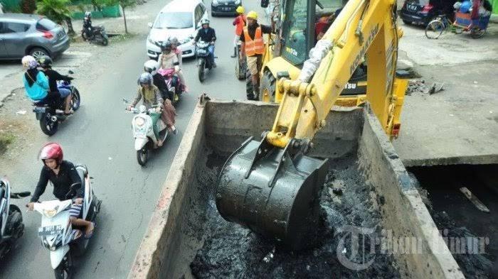 Alat berat ekskavator bersama pekerja dari Satgas Drainase menggali sedimen yang menghambat saluran drainase air di Jl Rappocini, Makassar, Rabu (21/2/2018). Musim Hujan Tiba, ini yang dilakukan Dinas PU Kota Makassar antisipasi banjir di Makassar